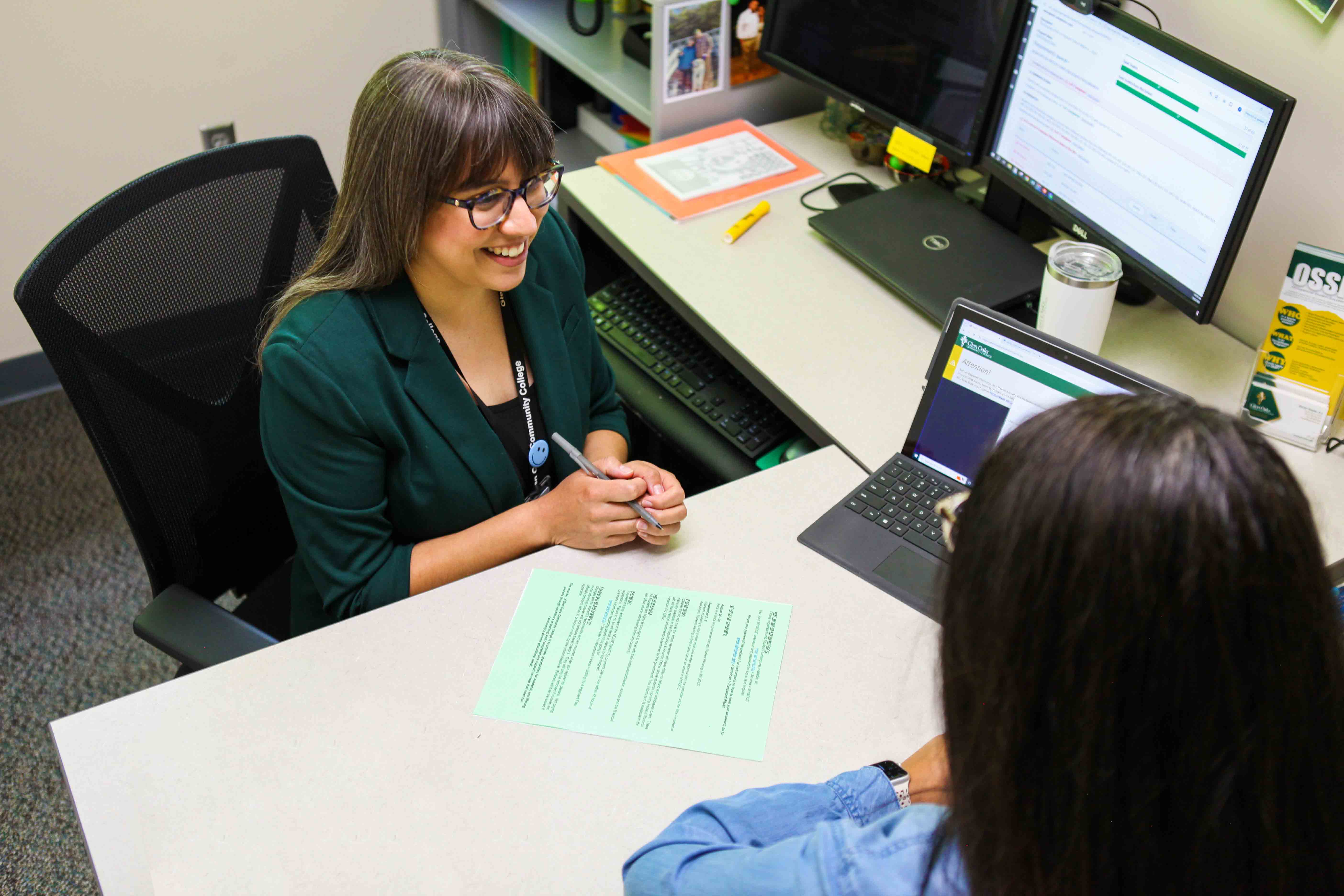 Advisor sitting at a desk across from a student