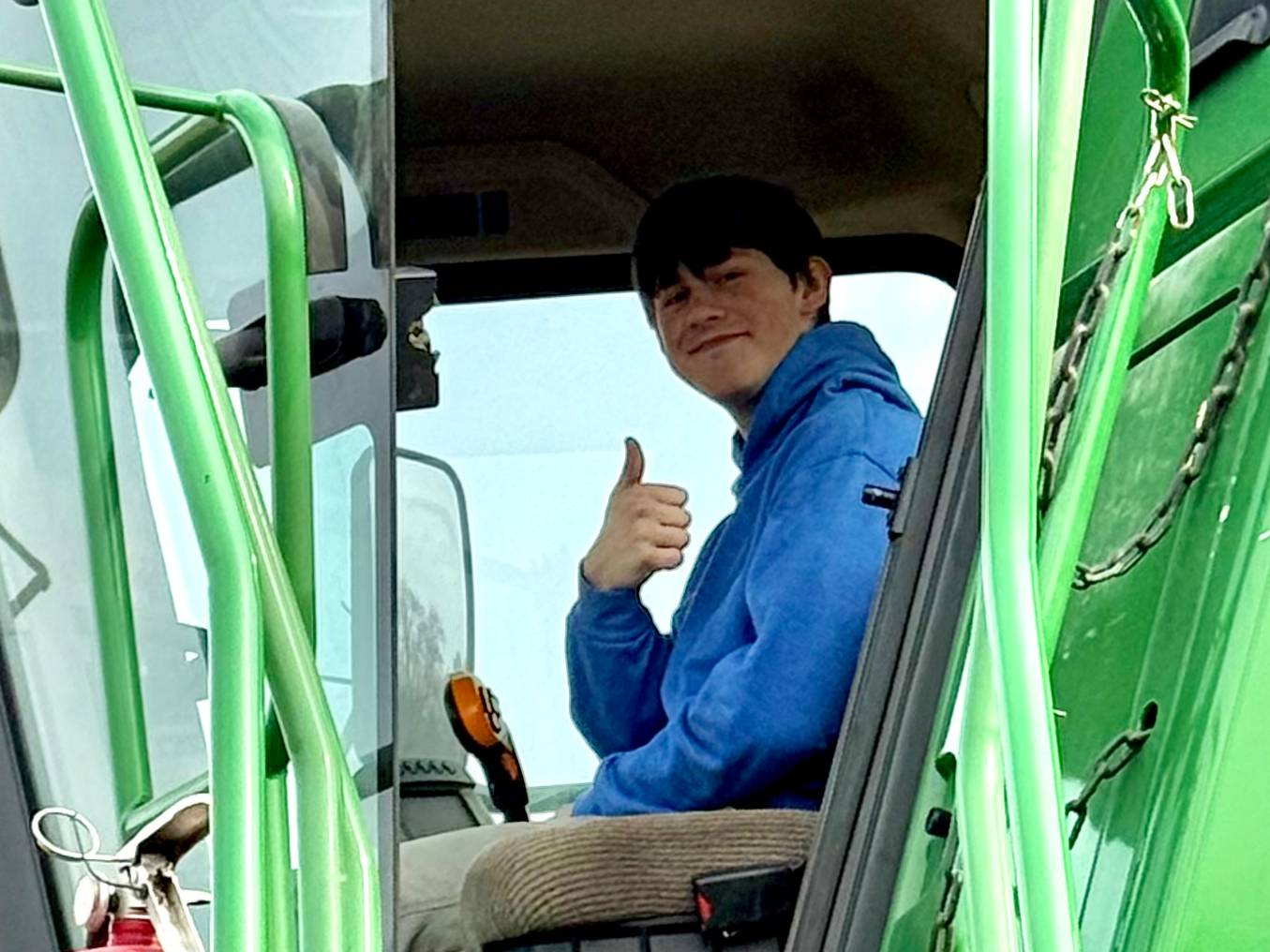 student sitting in green combine