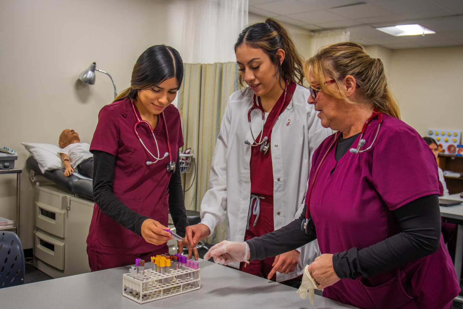 Three allied health students storing blood vial tubes.