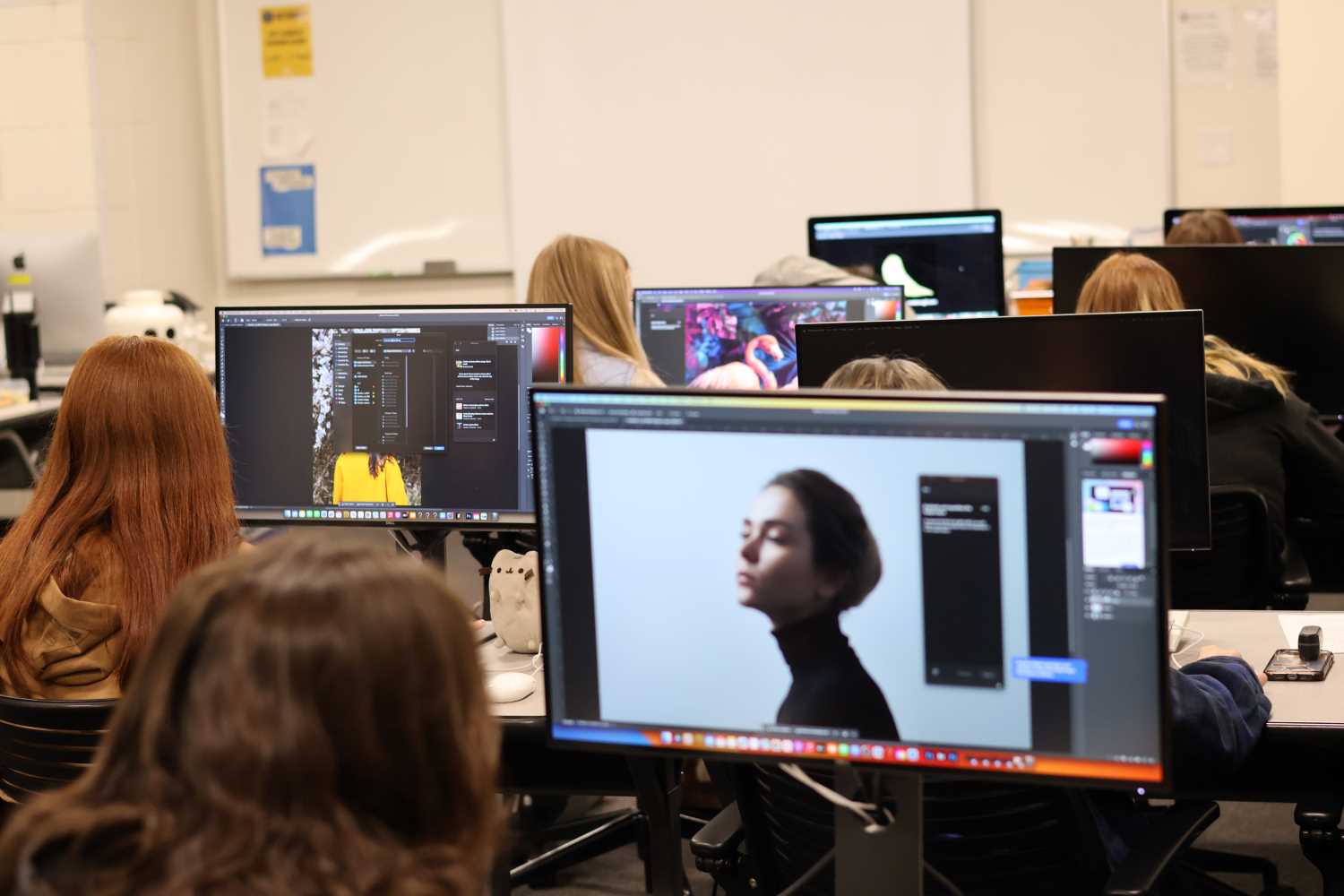 students sitting in art class in front of computer screens editing photography