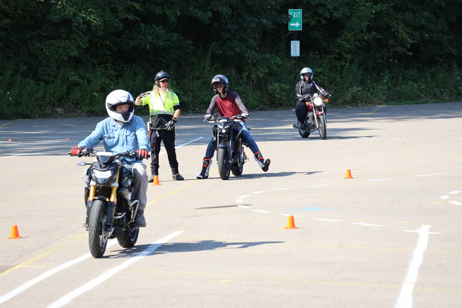 Students wearing helmets sitting on motorcycles
