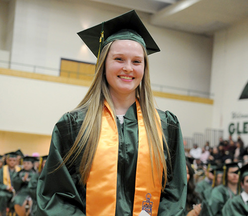 Female student in cap and gown at graduation.