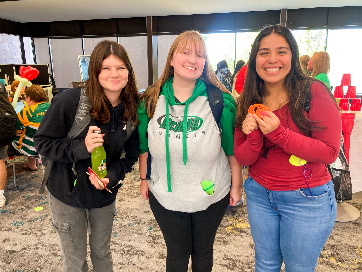 Three students standing and smiling for the camera