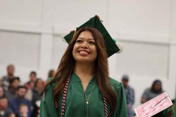 female trio student in cap and gown at graduation